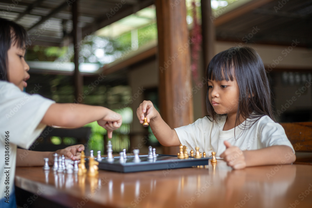 Fototapeta premium Two young girls playing a game of chess