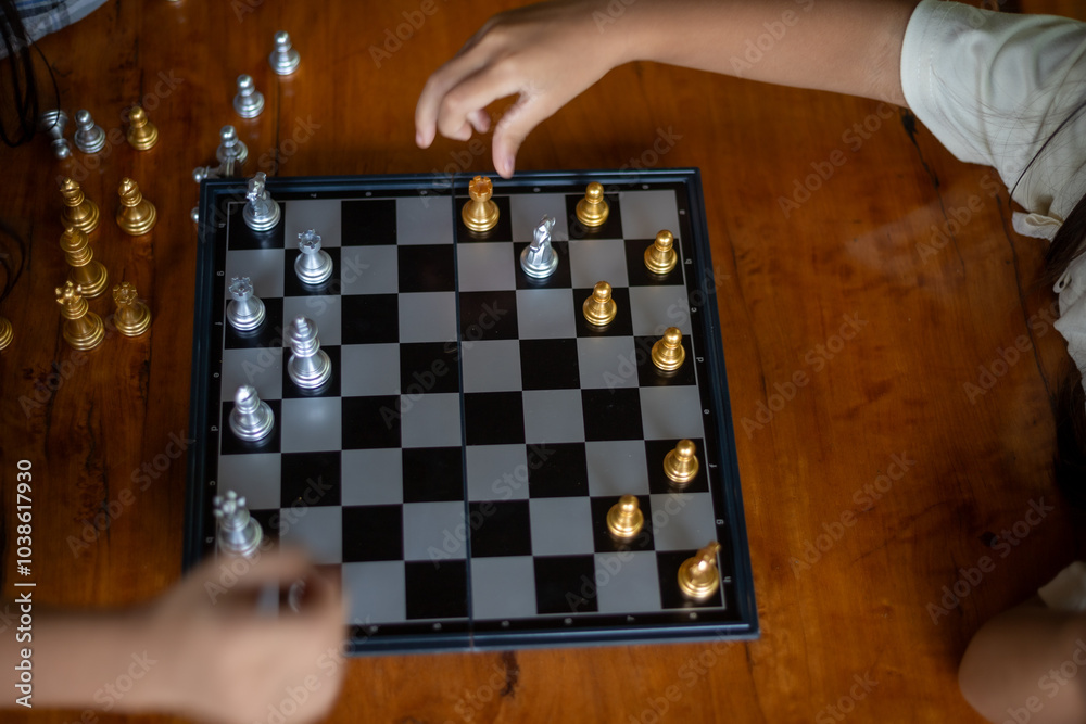 Two people playing a game of chess on a wooden table Two people playing a game of chess on a wooden table