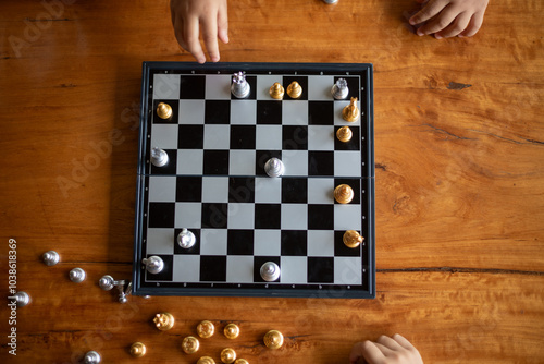 Two people playing chess on a wooden table photo