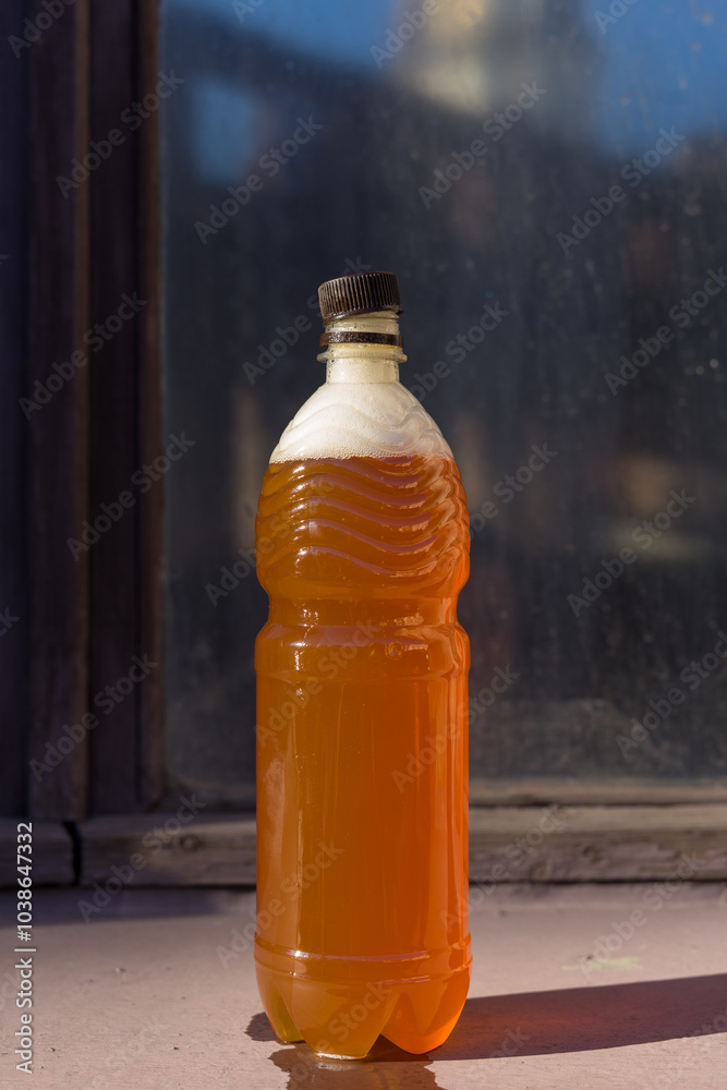 Plastic bottle of beer against the background of an old window Plastic bottle of beer against the background of an old window