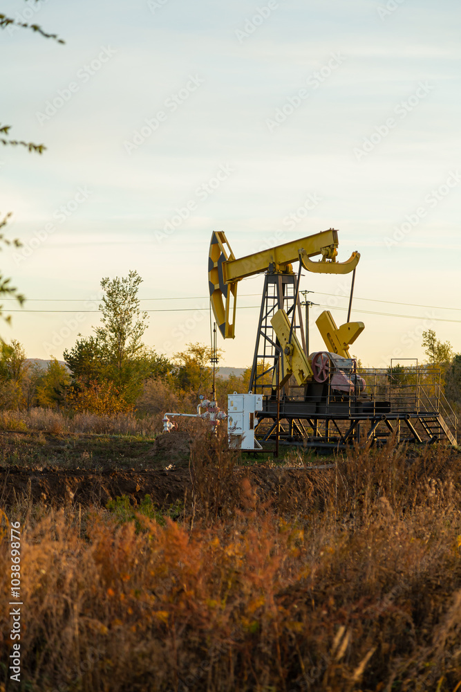 Oil well drilling rig in the middle of autumn field on a clear evening Oil well drilling rig in the middle of autumn field on a clear evening