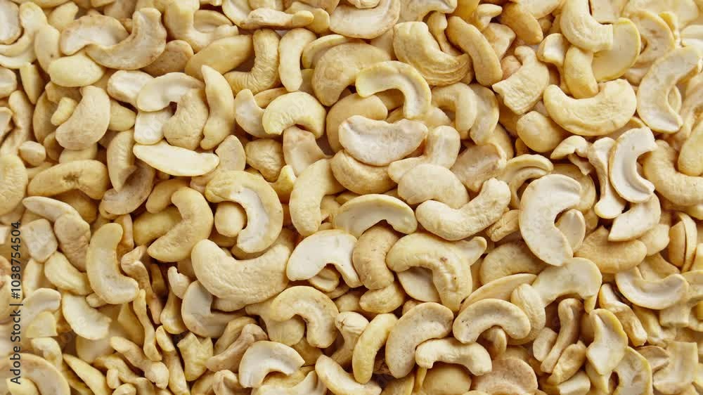 Rotating cashews. View from above. Healthy vegan food concept. Group of peeled cashews. Harvest of nutrient rich snack. Top view. Close-up in 4K, UHD Rotating cashews. View from above. Healthy vegan food concept. Group of peeled cashews. Harvest of nutrient rich snack. Top view. Close-up in 4K, UHD