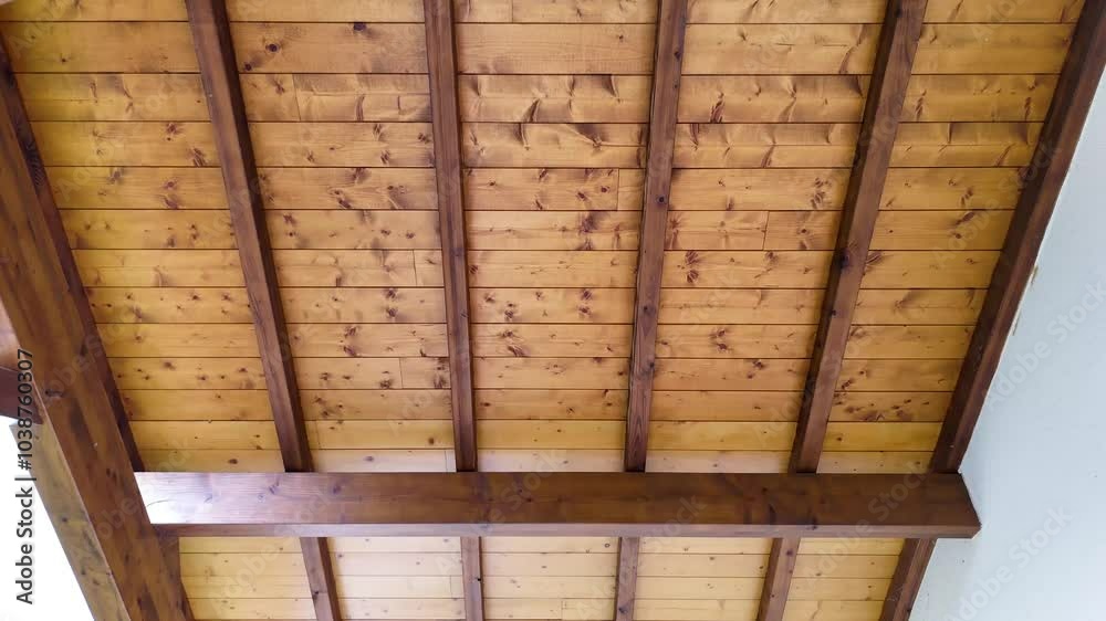 GROS PLAN SOUS TOITURE EN BOIS AVEC CHARPENTE VISIBLE, TOIT DOUBLE PANS AU-DESSOUS DE TOIT EN PIN VERNIS SOUS UN CIEL BLEU 