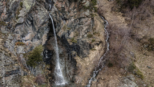 Beautiful waterfall in the mountains. A mountain river flows down. Beautiful nature. Stones and water.	