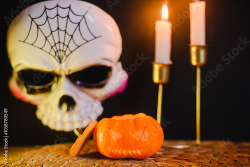 A small pumpkin for Halloween, candles and a Jolly Roger mask photo