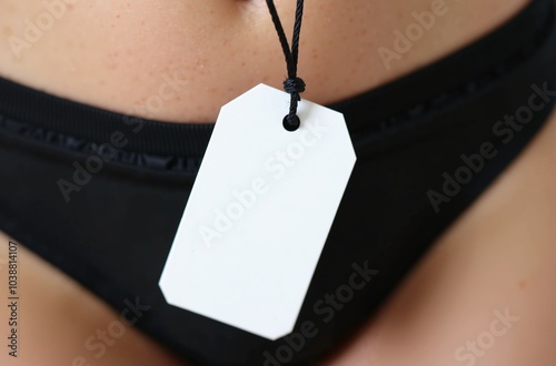 Close-up of blank price tag on black swim trunks, ready for sale. Customizable label for product branding and retail display in fashion stores.
