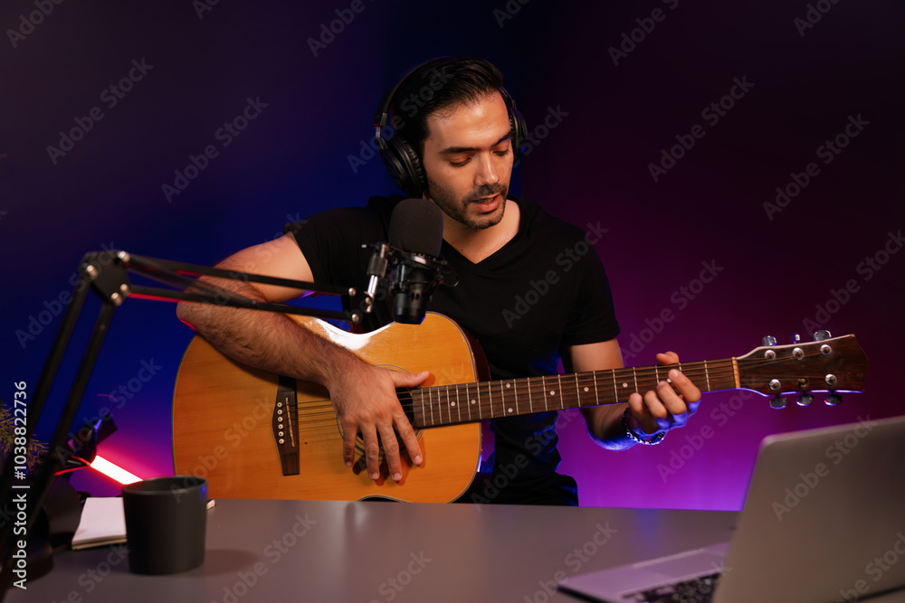 Obraz premium Host channel of smart influencer in creative audio on live streaming to fanclub with sing with play guitar music blogger using headset and mic social media online at neon light modern studio. Surmise.