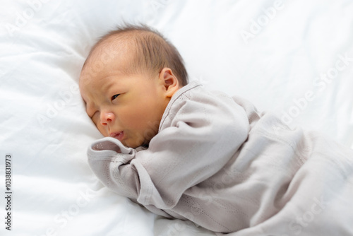 Newborn baby lying on bed