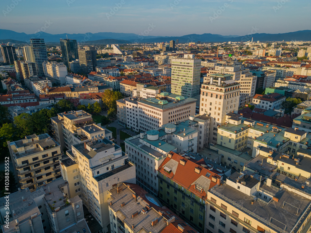 Ljubljana city center skyline aerial view at sunset. Urban area with historic Neboticnik skyscraper towards business district on Dunajska road with skyscrapers of modern architecture in capital city.