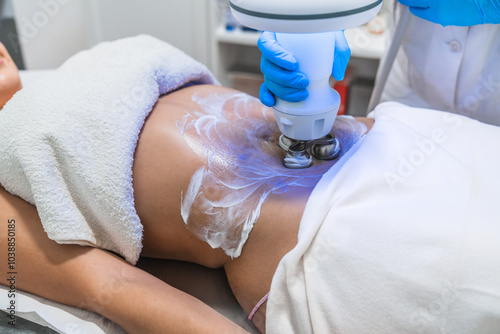 Photography Beautician applying gel for hardware body shaping procedure