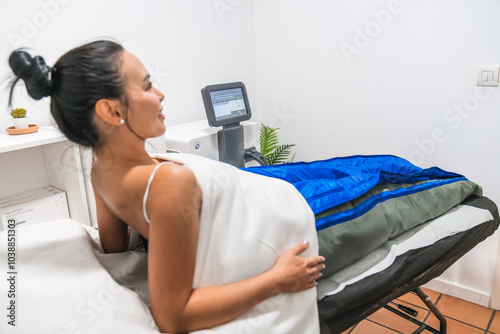 Tableau sur toile Woman lying down having pressotherapy treatment in beauty clinic