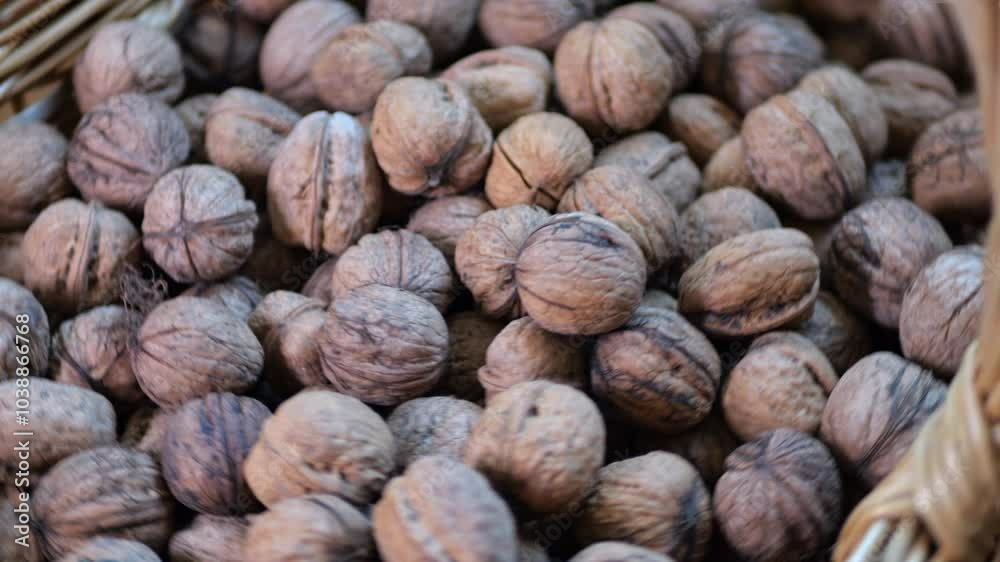 A pile of shelled walnuts in a large wicker basket close up of walnuts A pile of shelled walnuts in a large wicker basket close up of walnuts