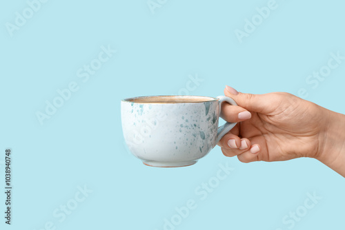 Female hand holding cup of ...