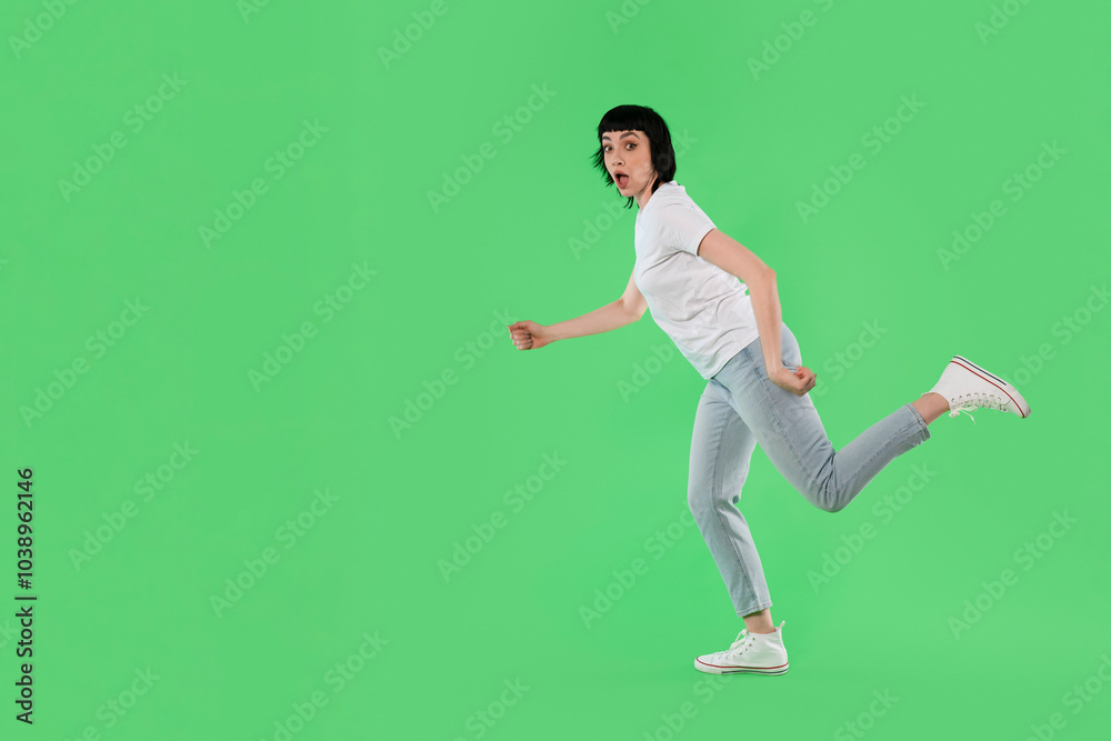 Woman running in surprise on a bright green background during daylight hours Woman running in surprise on a bright green background during daylight hours