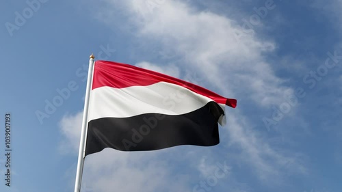 Flag of Yemen on a blue sky, flag on a flag pole waving in the wind, middle east country, national symbol of Yemen, video of a flag photo