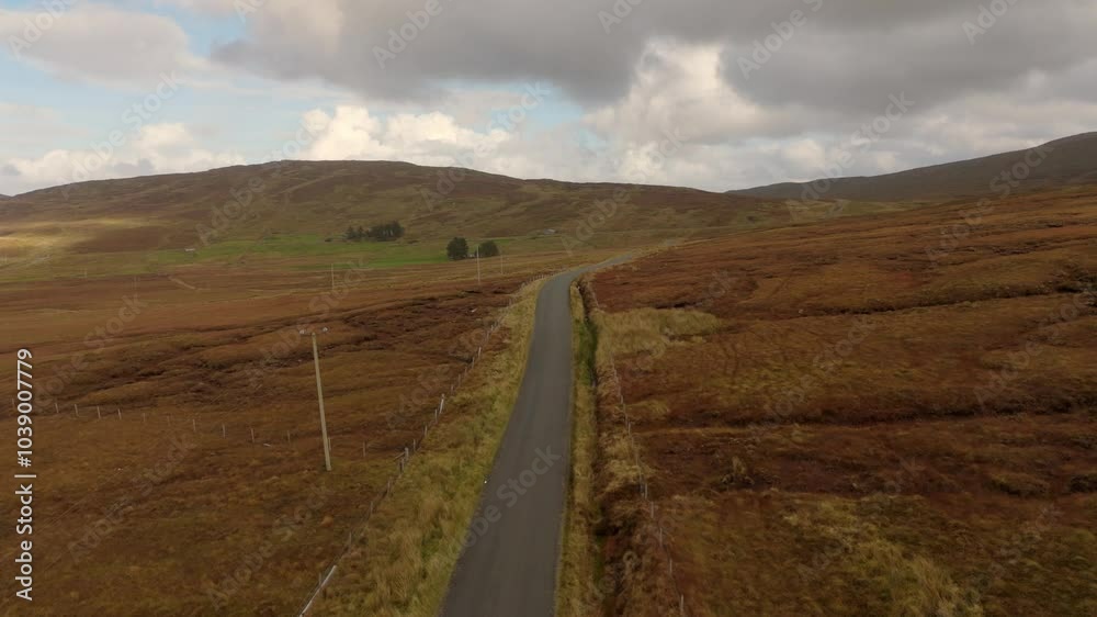 A tranquil and serene road beautifully intersects with stunning countryside landscapes beneath a cloudy sky A tranquil and serene road beautifully intersects with stunning countryside landscapes beneath a cloudy sky