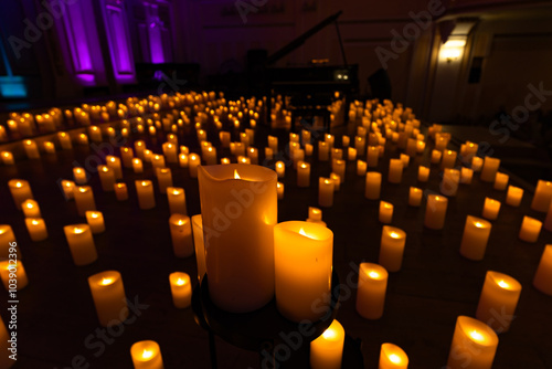 blurred symphonic orchestra on stage with lots of candles