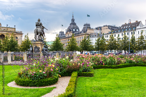 famous cobblestone square in a park full of flowers with an equestrian statue of King Christian V. in copenhagen, denmark
