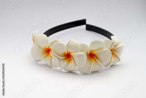 Carta da parati Black plastic headband decorated with white frangipani flower ornaments, isolated on white background