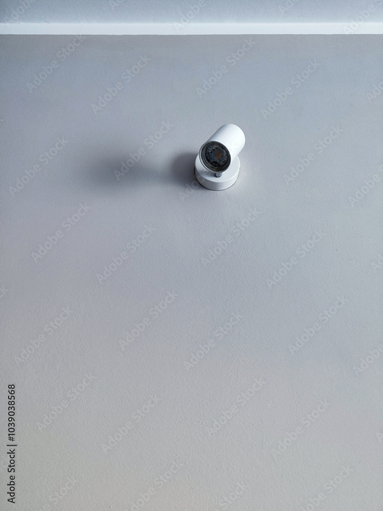 Minimalist White Wall with a Modern Mounted Spotlight Minimalist White Wall with a Modern Mounted Spotlight