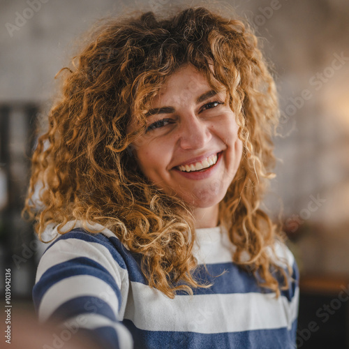 Portrait of adult caucasian woman with curly hair at home happy smile