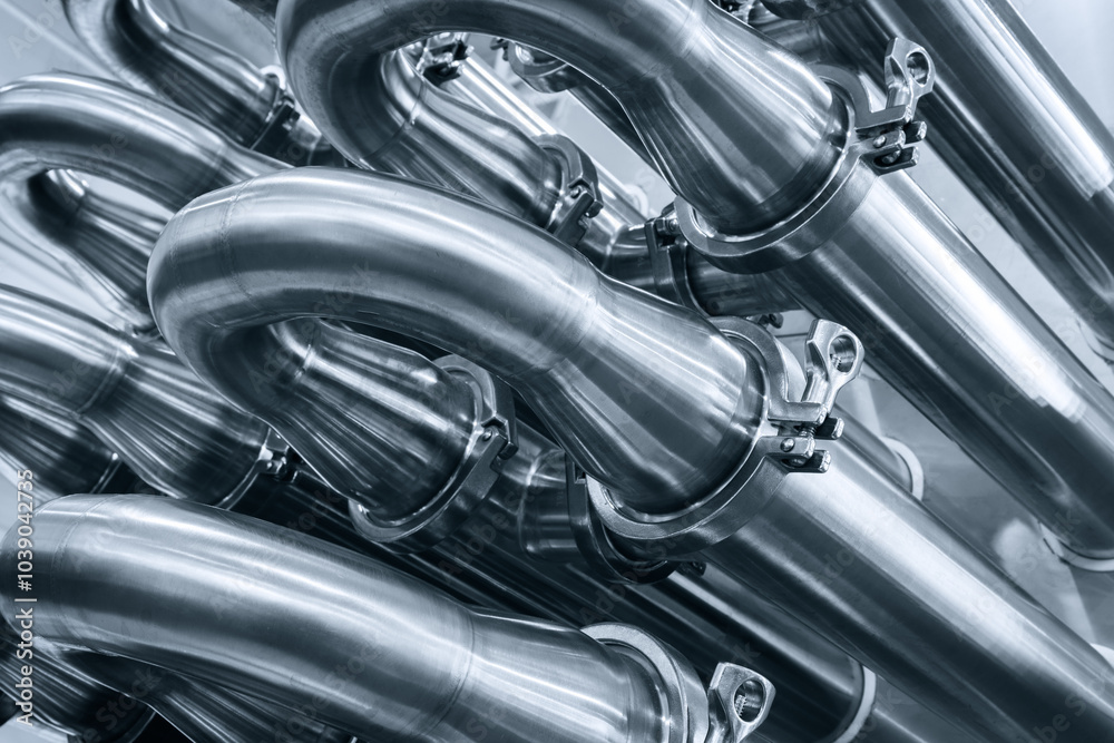 A series of pipes are shown in a close up. The pipes are silver and appear to be connected to one another. Concept of industrial machinery and the importance of the pipes in the process A series of pipes are shown in a close up. The pipes are silver and appear to be connected to one another. Concept of industrial machinery and the importance of the pipes in the process
