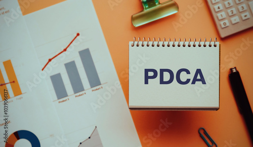 There is notebook with the word PDCA. It is an abbreviation for Plan, Do, Check, Act as eye-catching image.