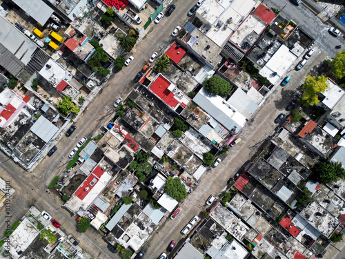 Aerial top-down view high altitude of slum a heavily populated urban informal settlement characterized by substandard housing and squalor poor living conditions streets and rusty metal home roof tops