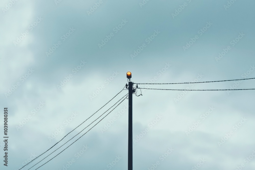 A Single Light on a Power Pole Against a Cloudy Sky A Single Light on a Power Pole Against a Cloudy Sky