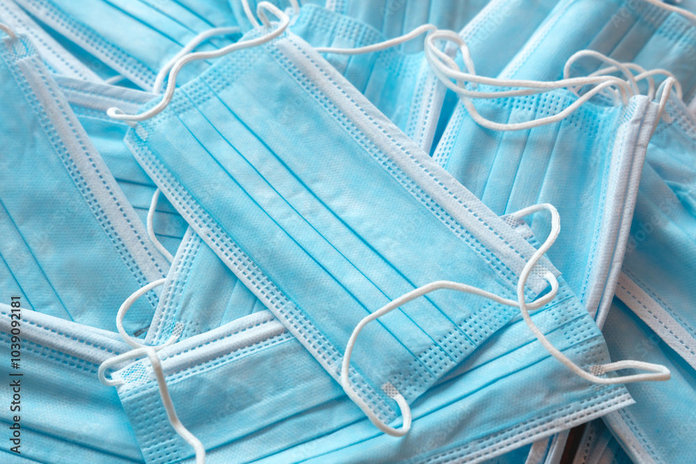 Many sterile medical blue disposable masks. Stack of new medical masks organized.