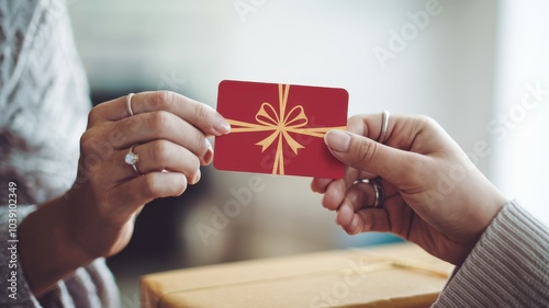 Gift card exchange between two hands, soft blurred background. photo