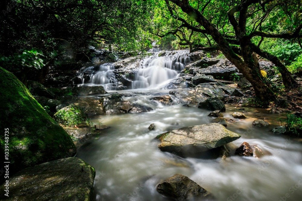 Fototapeta premium Serene Waterfall Cascading Over Smooth Rocks in Nature, Little Hawaii Falls, Hong Kong