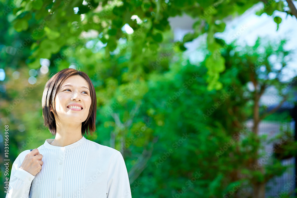 緑地を散歩する女性