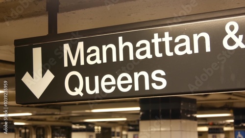 New York subway station interior, Manhattan text sign. Underground metropolitan. United States metro transport navigation. Information signage public passenger railway. Downtown and Queens direction.