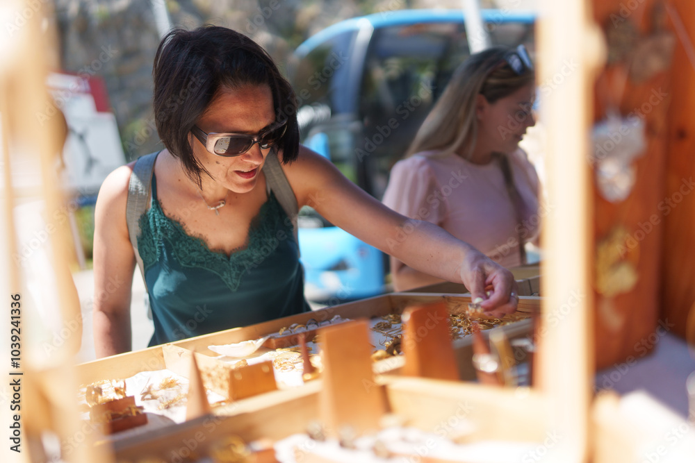 Fototapeta premium Woman looking at jewelry at a street market