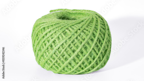 Close-up of a green ball of twine isolated on a light background, perfect for crafting or design projects. Green Ball of Twine Close-Up