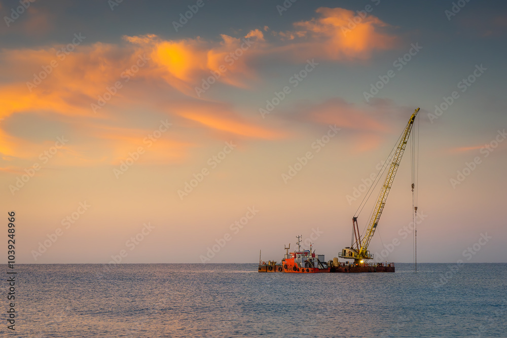 Fototapeta premium Floating crane on the sea at sunrise. Industrial landscape.