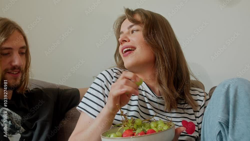 A Woman Teases Man Over Grapes While Sitting In A Couch. Slow Motion Shot A Woman Teases Man Over Grapes While Sitting In A Couch. Slow Motion Shot