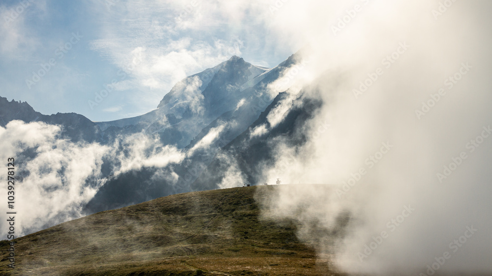 Morning view of Alpien tops with broken clouds, early sun rays and helicopter on small meadow Morning view of Alpien tops with broken clouds, early sun rays and helicopter on small meadow