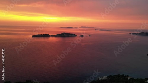 Drone capture of the sunset’s vibrant hues painted the ocean and sky, casting a warm glow as the fading light silhouetted the tranquil waters below. photo