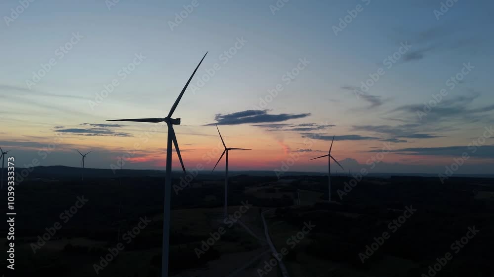 Scenic Aerial view of wind turbines farm in sunset time. Wind turbine producing alternative energy Scenic Aerial view of wind turbines farm in sunset time. Wind turbine producing alternative energy