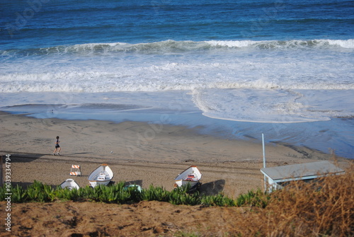 2023 December, Torrance, California.  Heavy Surf with Runner on Beach.