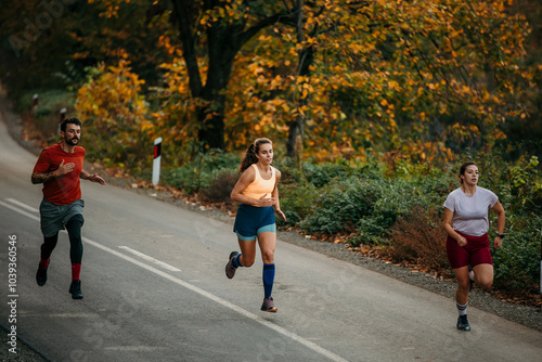 Three runners sprinting outdoors - Sportive people training in a nature area, healthy lifestyle and sport concepts