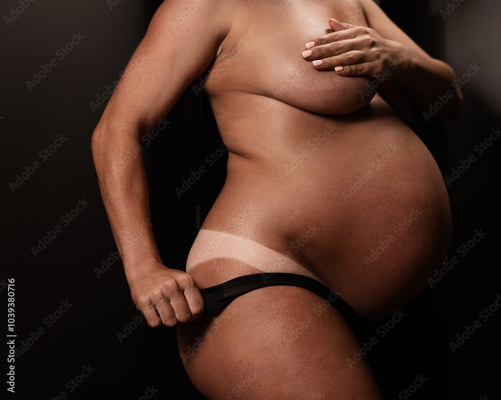 Naklejka premium Pregnant woman pulls back her panties showing instant tan. Vertical photo. 