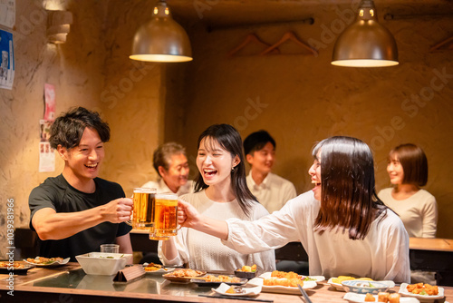 居酒屋でお酒を飲む若い男女