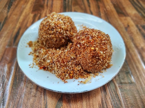 Ketan Serundeng. Indonesian cuisine. Savory steamed cake of glutinous rice with coconut milk, topped with spicy roasted desiccated coconut. photo