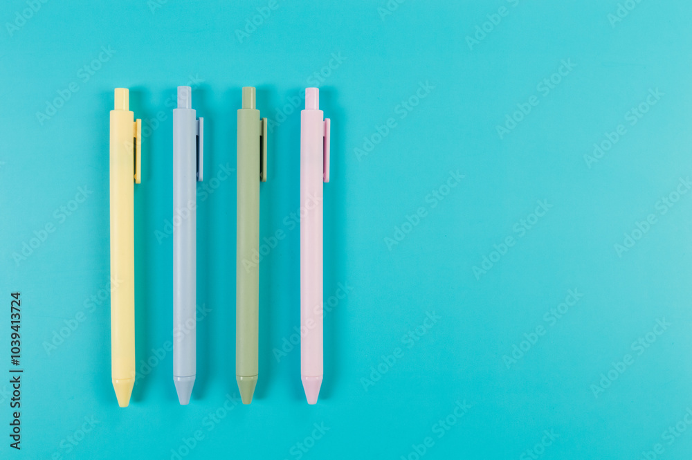 Top view of colorful pens on blue background. School, office wallpaper. Flat lay, copy space.