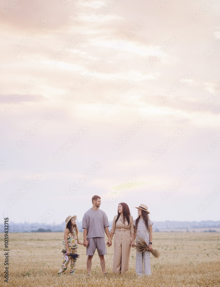 Happy family with two daughters standing on golden wheat field Happy family with two daughters standing on golden wheat field
