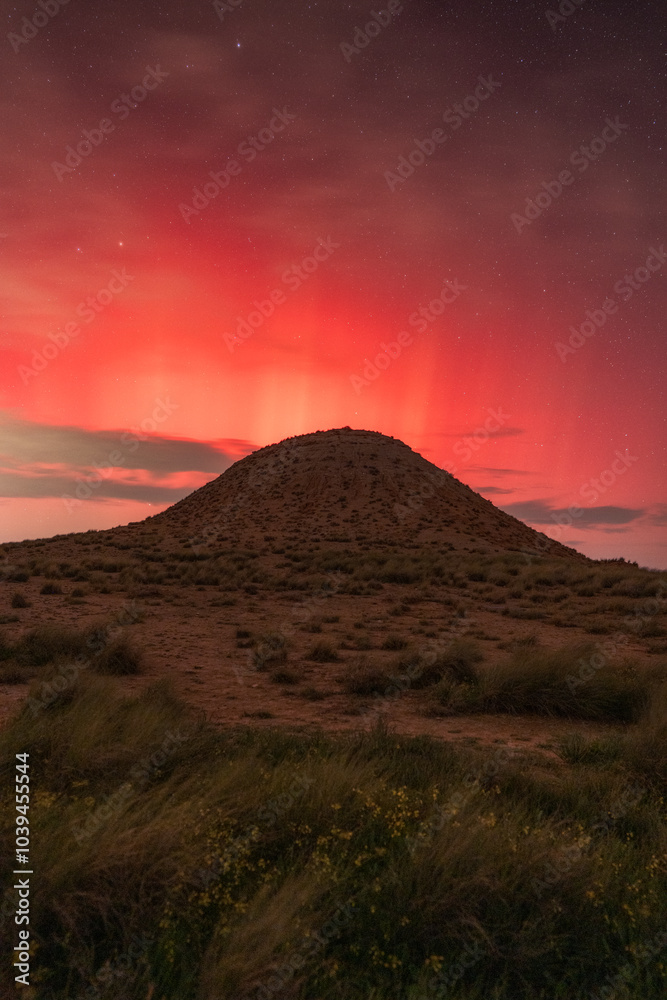 Aurora boreal rosa en la noche detrás de un cerro en la noche Aurora boreal rosa en la noche detrás de un cerro en la noche
