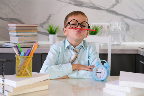 Happy kid in tie and shirt is messing around with schoolwork. Concept of teaching and educational work. Classes for children at home. Business school, investment and financial education for children. photo